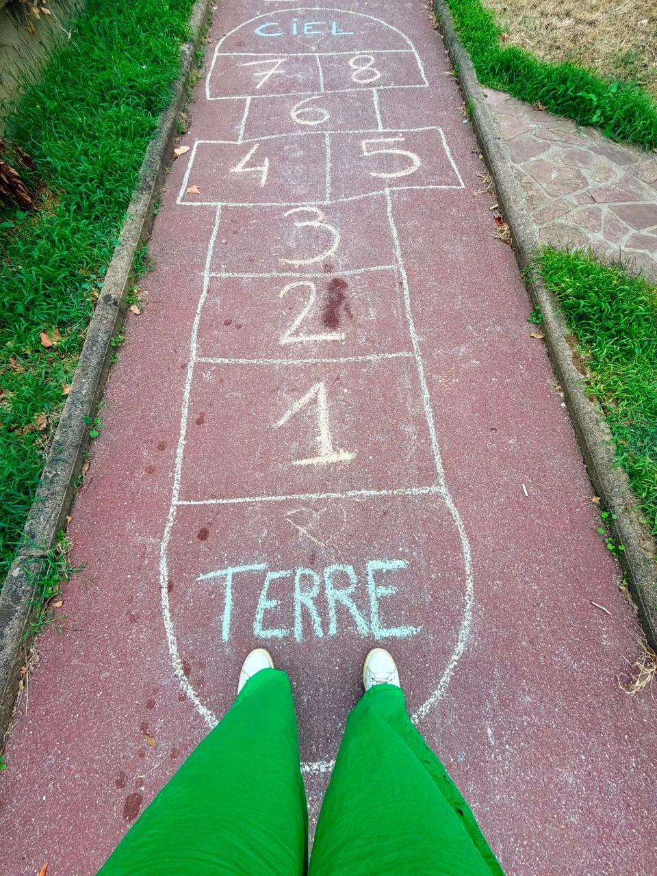 Marelle dessinée à la craie, de « Terre » à « Ciel », vue depuis la case de départ